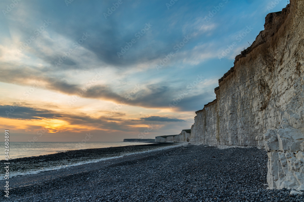 Stunning landscape image of white chalk cliffs with colorful vibrant sunset on English coast