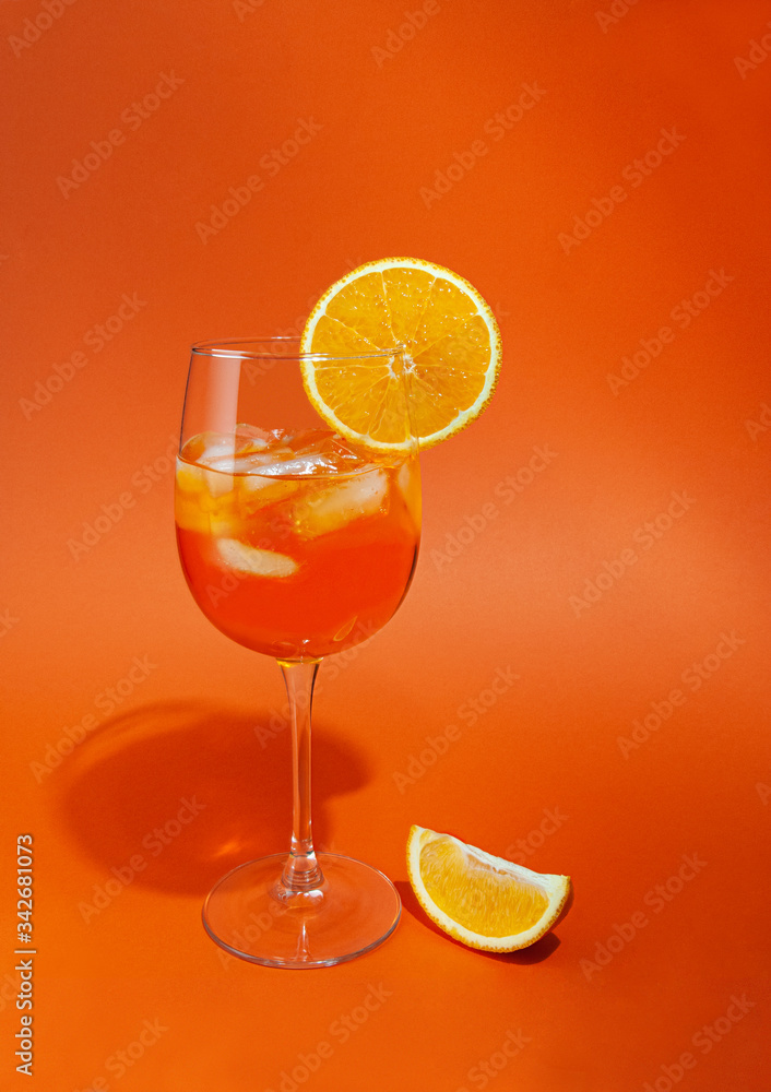 Cocktail aperol spritz with ice. In a glass goblet. On a glass of orange slice. Next to the glass is a slice of orange. Cocktail aperol spritz with ice. In a glass goblet. On a glass of orange slice. Next to the glass is a slice of orange.