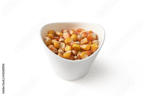 Ziarna kukurydzy w małej misce na białym tle