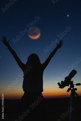 Silhouette of a woman and telescope with twilight sky. © astrosystem