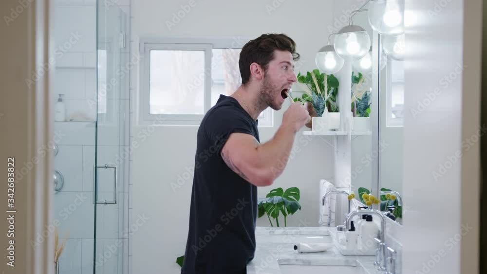 Man Wearing Pyjamas Standing At Sink Brushing Teeth In Bathroom Man Wearing Pyjamas Standing At Sink Brushing Teeth In Bathroom
