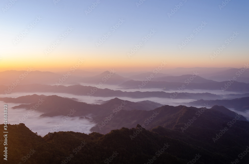 Silhouette of beautiful natural view on top of the mountain in national park with overcast sky and foggy landscape at the morning  in the summer time.