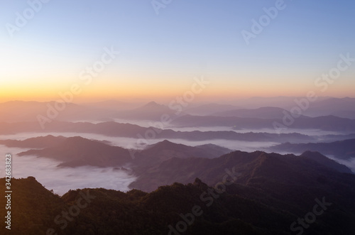 Silhouette of beautiful natural view on top of the mountain in national park with overcast sky and foggy landscape at the morning in the summer time.