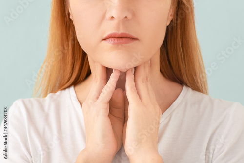 Woman with thyroid gland problem on light background