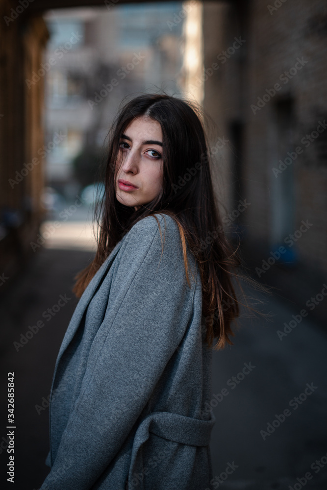 Girl in a red blouse and a gray cardigan on the background of the old brick wall Girl in a red blouse and a gray cardigan on the background of the old brick wall
