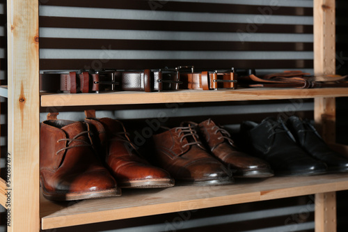 Wooden shelving unit with different leather shoes and belts