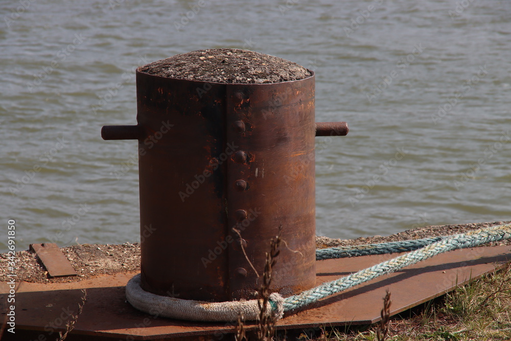 Steel bollards on the quay of the port of Rotterdam where ships moor and attach themselves with ropes or chains Steel bollards on the quay of the port of Rotterdam where ships moor and attach themselves with ropes or chains