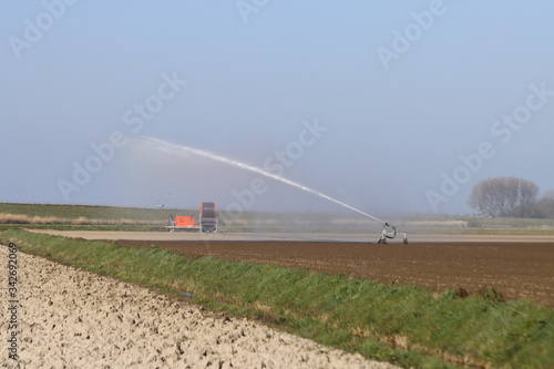 Dry clay fields are sprayed by farmers with water on the island of Goeree Overflakkee in the Netherlands © André Muller