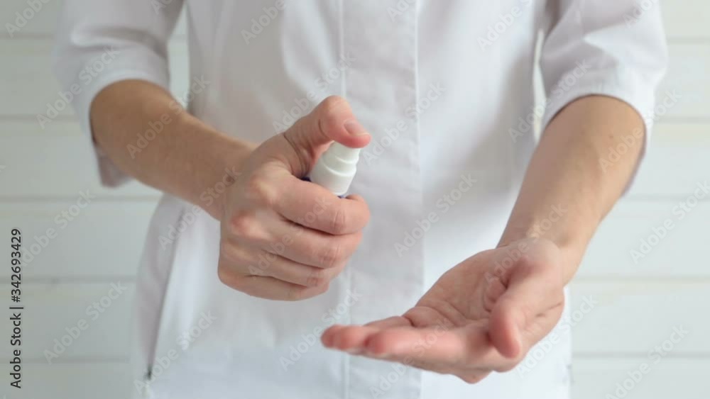 Torso of a woman in doctor's clothes disinfects her hands during a pandemic, epidemic COVID-19 Torso of a woman in doctor's clothes disinfects her hands during a pandemic, epidemic COVID-19