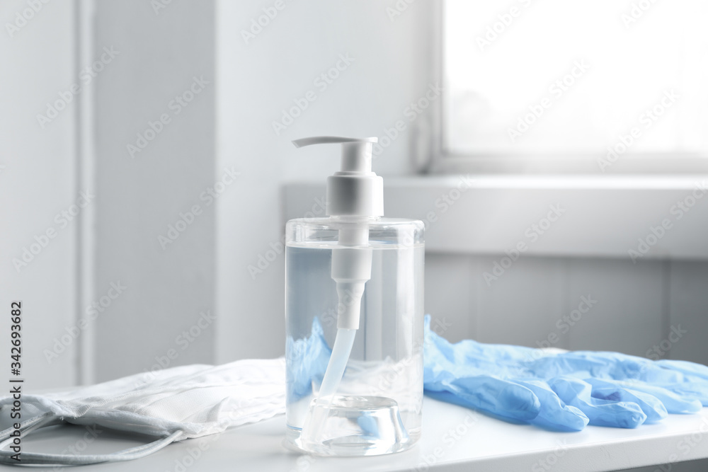 Antiseptic gel, protective gloves and masks on table indoors. Protection from virus Antiseptic gel, protective gloves and masks on table indoors. Protection from virus