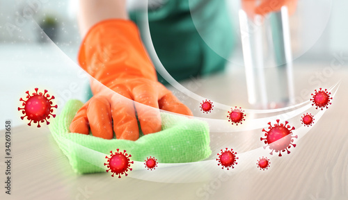 Cleaning vs viruses. Woman washing table with sponge and disinfecting solution