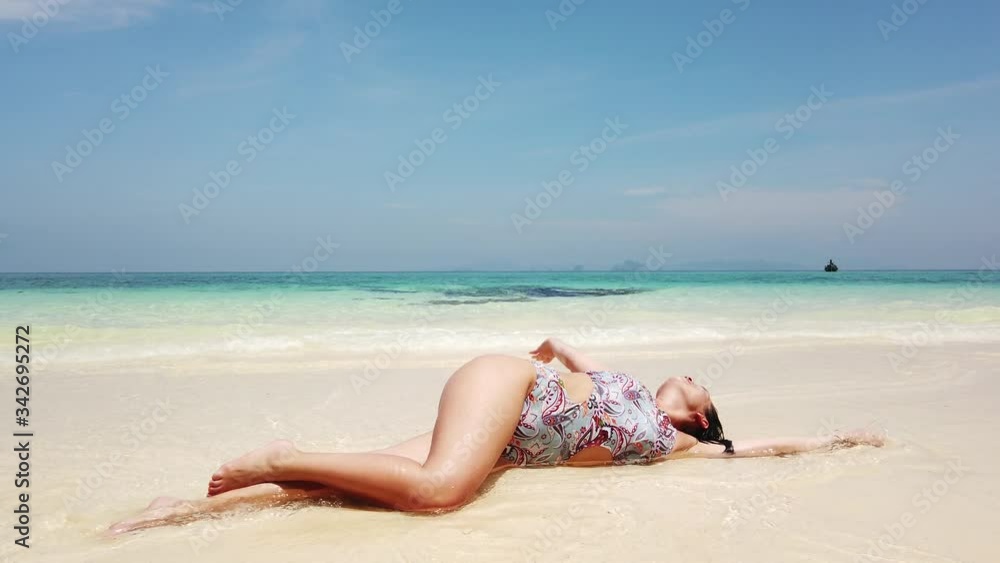 Beautiful brunette girl bathes on the beach of a tropical island Beautiful brunette girl bathes on the beach of a tropical island