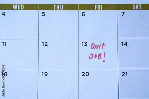 Quit job words written on table calendar with red marker
