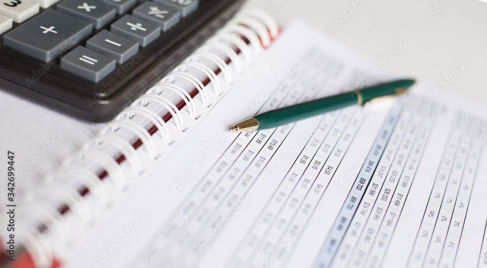 calculator, a pen and blank paper on the table calculator, a pen and blank paper on the table