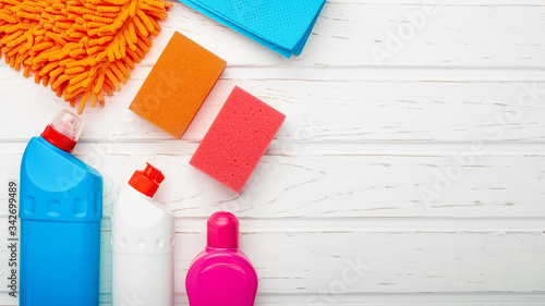 Cleaning supplies on wooden background with copy space