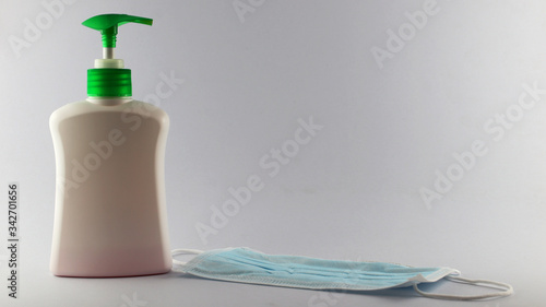 Liquid soap to protect hands against viruses, white bottles, green pumps, white background, coronaviruses, Covid-19