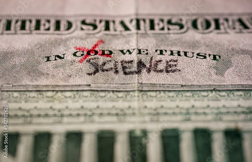 Картината върху платно word God crossed out and replaced by science on a US dollar bill