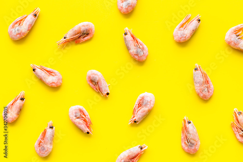 Shrimps - frozen - pattern on yellow background top view