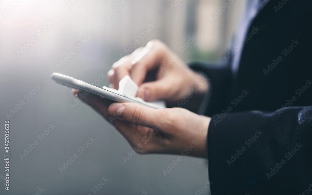 Smartphone screen disinfection using wet wipes and sanitizer. Coronavirus Covid 19 pandemic worldwide. Men's hands wipe the phone Smartphone screen disinfection using wet wipes and sanitizer. Coronavirus Covid 19 pandemic worldwide. Men's hands wipe the phone