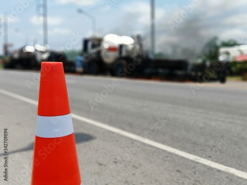 Road maintenance by the ASPHALT HOT MIX IN - PLACE RECYCLING method and with a red cone in the front (blurred image).