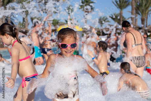  little girl and group of people having fun in the pool
