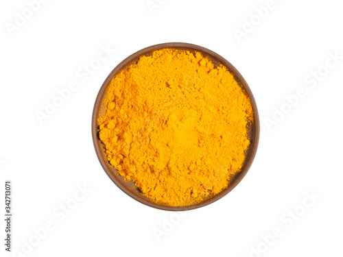 Turmeric (curcuma) powder on brown clay plate isolated on white