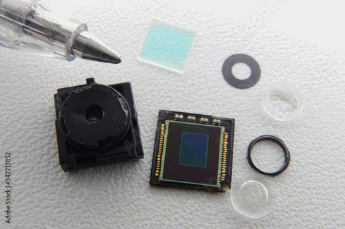 Smartphone camera teared down to it's component. Sizes compared with the tip of a pen.