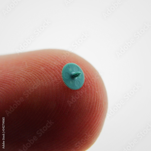 Small plastic green gear compared to finger tip