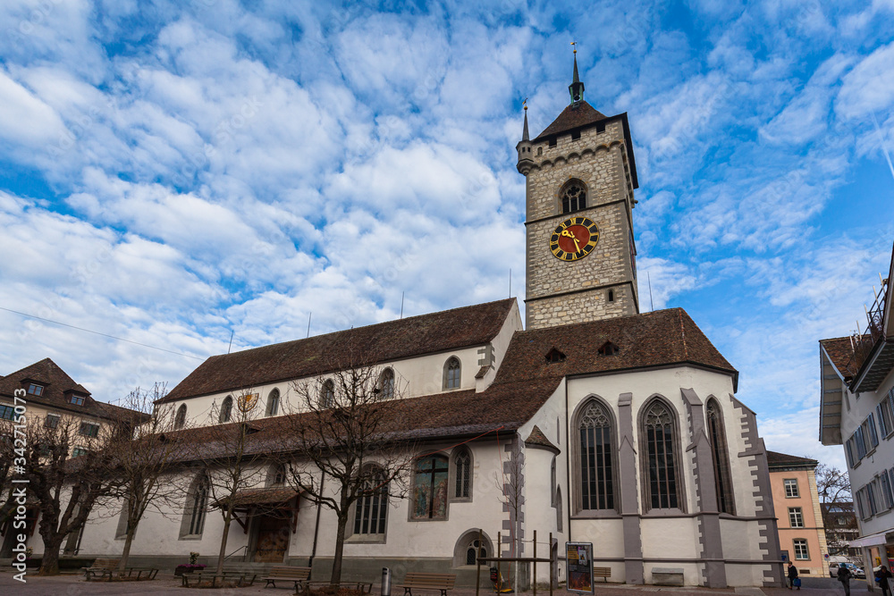 Close up exterior view of the St. Johann evangelic church in the old town of Schaffhausen city center on sunny day in autumn with blue sky cloud in background, Switzerland