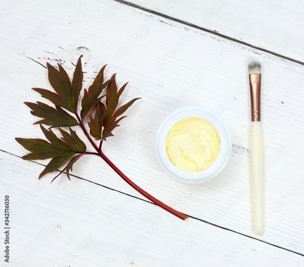 Raw shea butter for face and body care, top view. Good for smooth and healthy skin. White wooden table, cosmetic brush. Raw shea butter for face and body care, top view. Good for smooth and healthy skin. White wooden table, cosmetic brush.