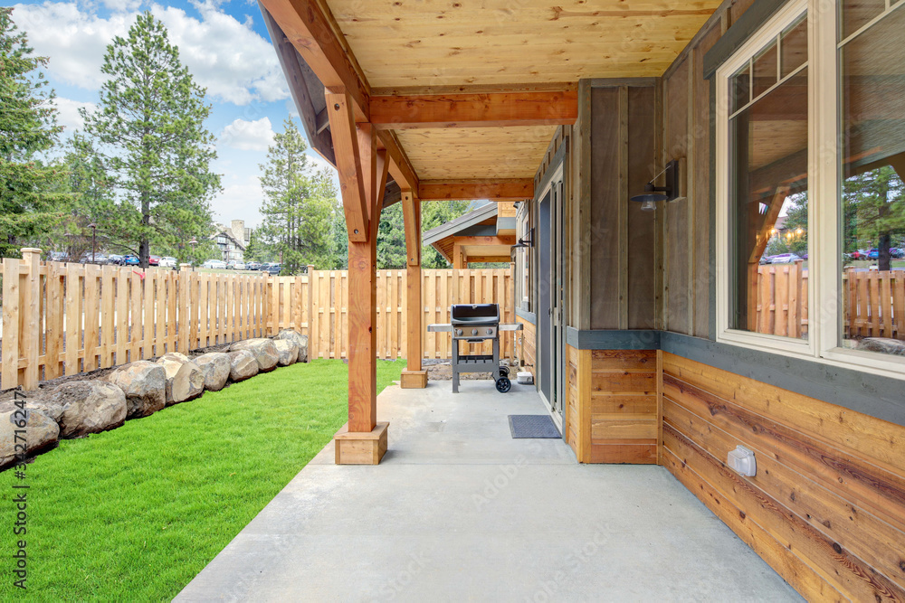 Small new back yard with wooden house and fence, fresh grass and BBQ on the concrete porch. Small new back yard with wooden house and fence, fresh grass and BBQ on the concrete porch.