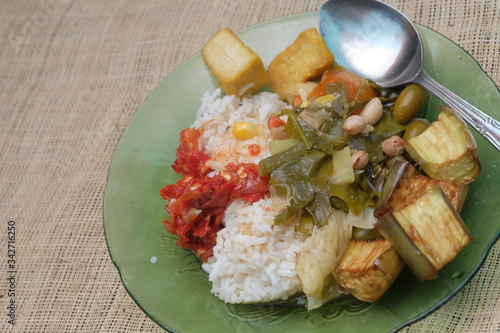 Indonesian traditional food, chilli paste, sour soup, fried eggplant and tofu with rice.