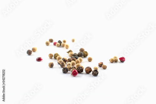 Red, green and black peppercorns or balls mixed isolated on a white background.