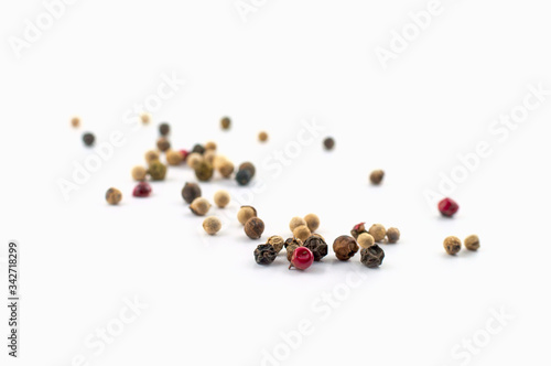 Red, green and black peppercorns or balls mixed isolated on a white background.