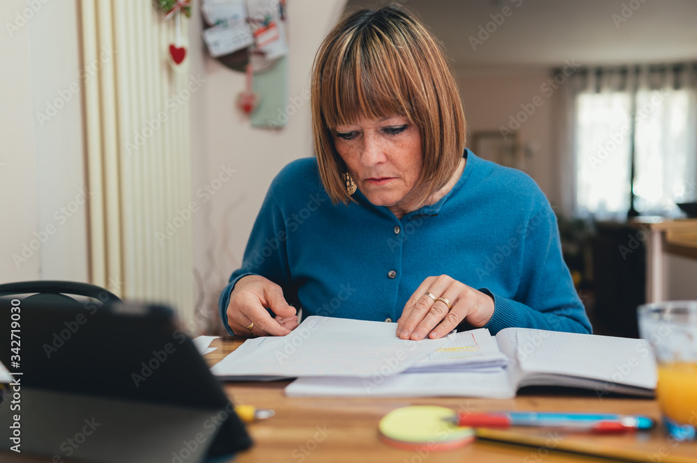 Anziana maestra/ lavoratrice lavora da casa in smart working. Distanza sociale e lavoro a distanza con il supporto della tecnologia Anziana maestra/ lavoratrice lavora da casa in smart working. Distanza sociale e lavoro a distanza con il supporto della tecnologia