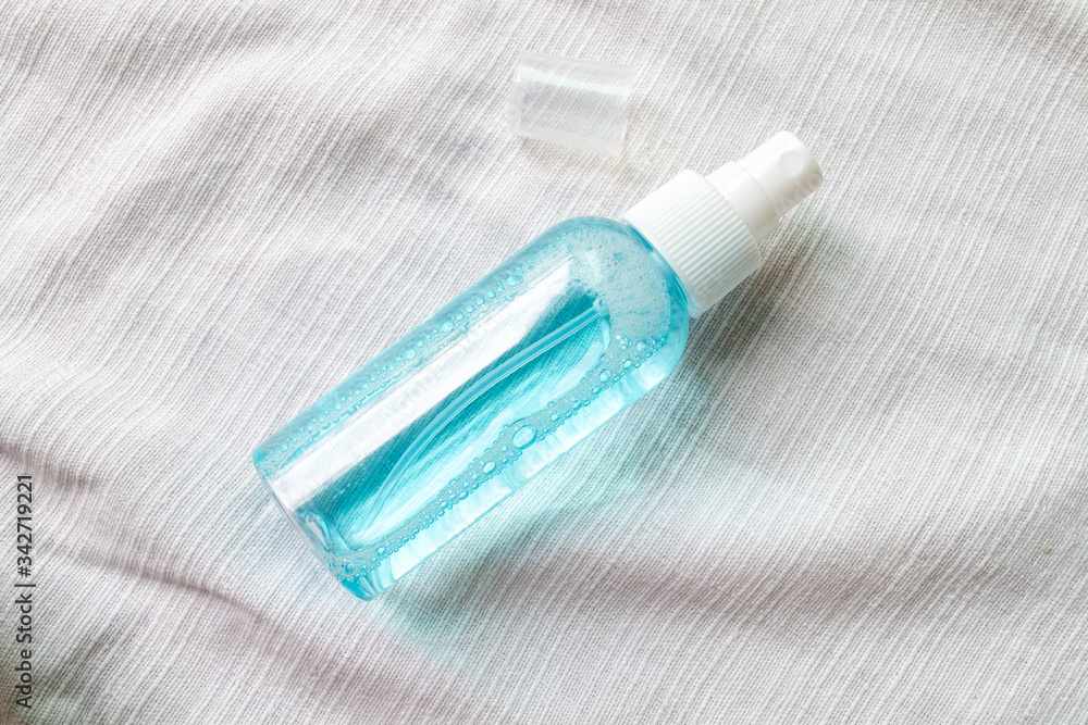Naklejka premium Alcohol spray bottle on a white fabric background
