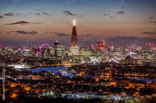 Die Skyline von London, Großbritannien, am Abend mit den beleuchteten Wolkenkratzern und zahlreichen Touristenattraktionen