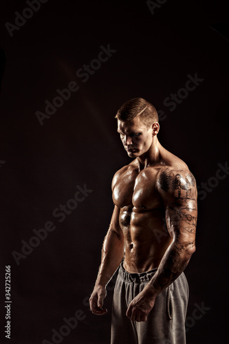 Studio portrait of a shirtless athletic tattooed male.