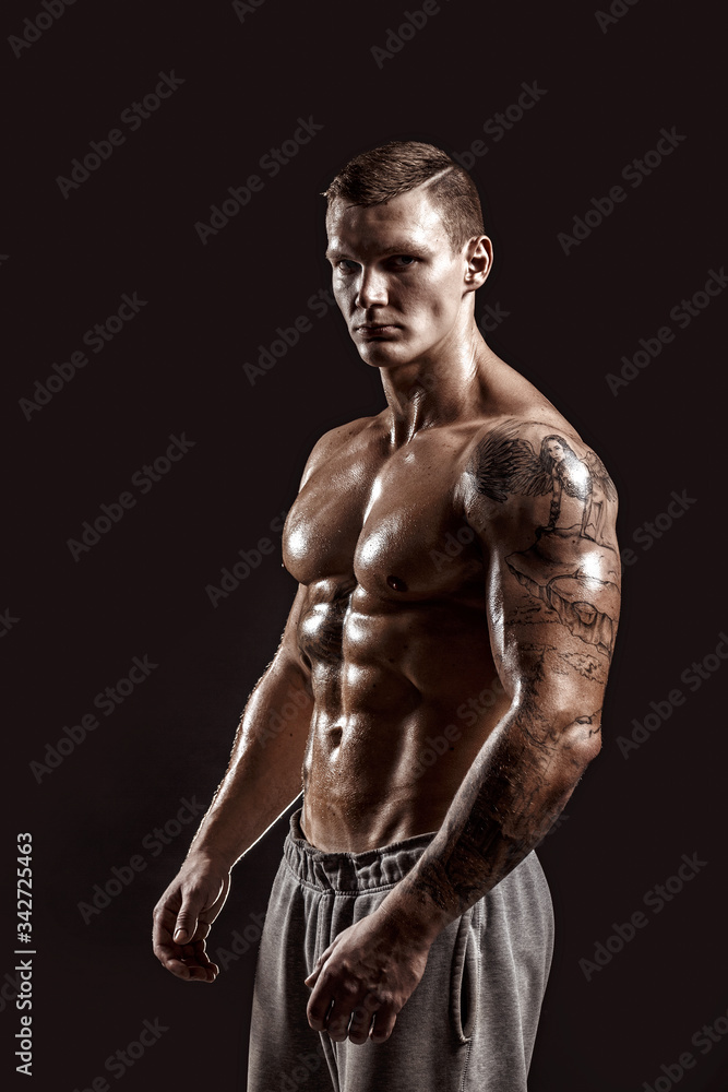 Studio portrait of a shirtless athletic tattooed male. Studio portrait of a shirtless athletic tattooed male.