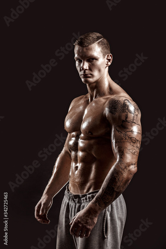 Studio portrait of a shirtless athletic tattooed male.