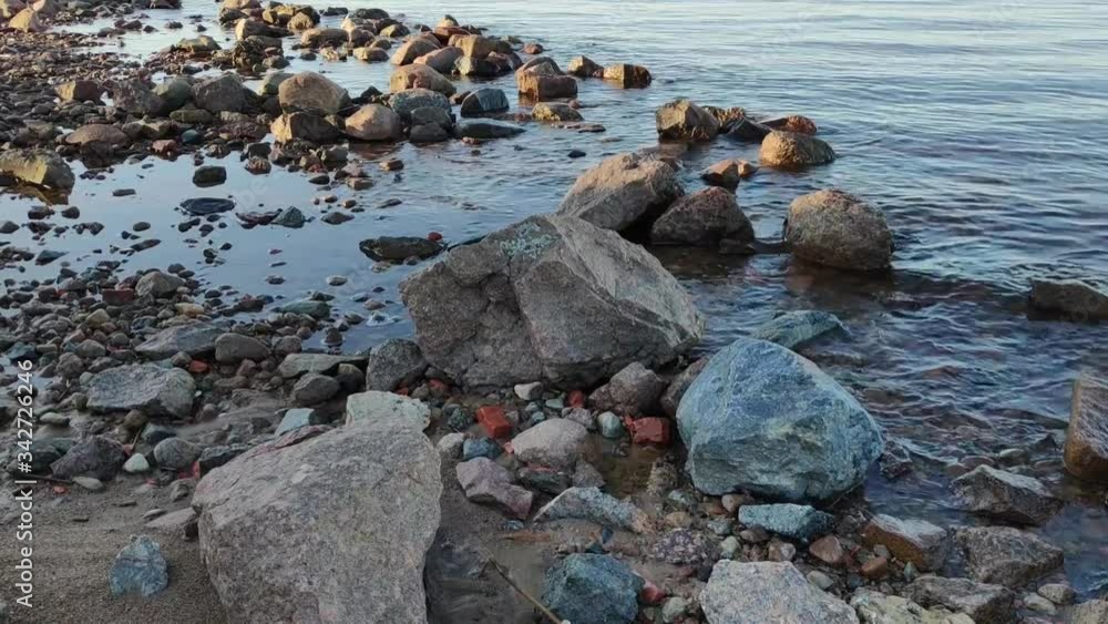 Beautiful river Bank, waves wash the sandy beach with granite stones. Beautiful river Bank, waves wash the sandy beach with granite stones.