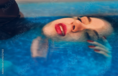 Model in colorful blue water like space. Deep color and texture.