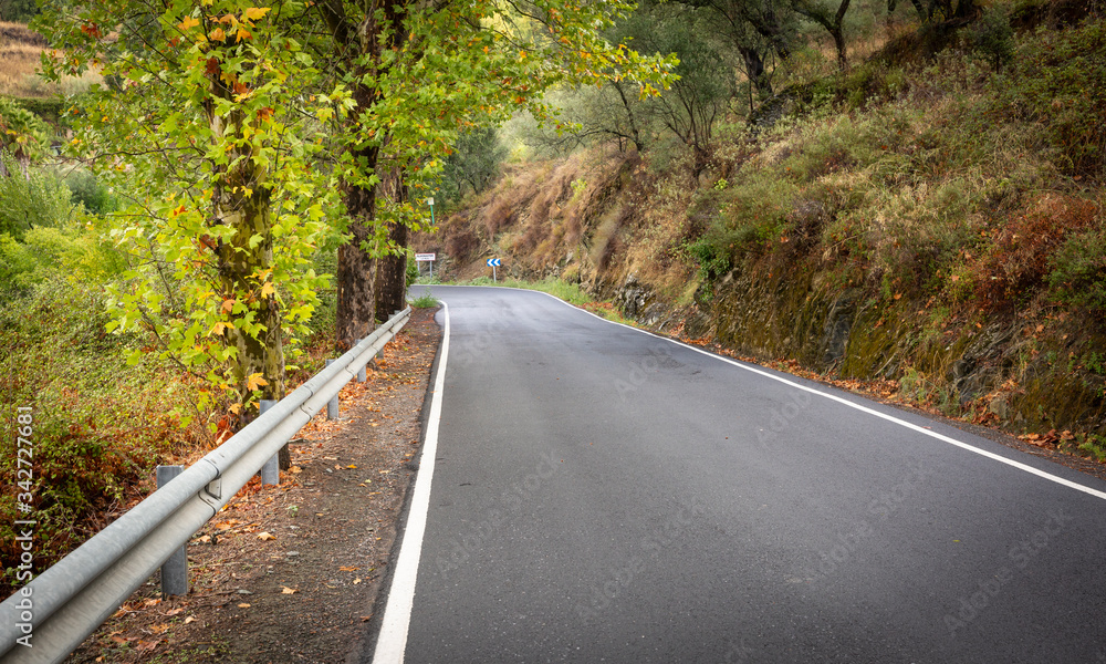 A paved road approaching Almonaster la Real town in Autumn, province of Huelva, Andalusia, Spain