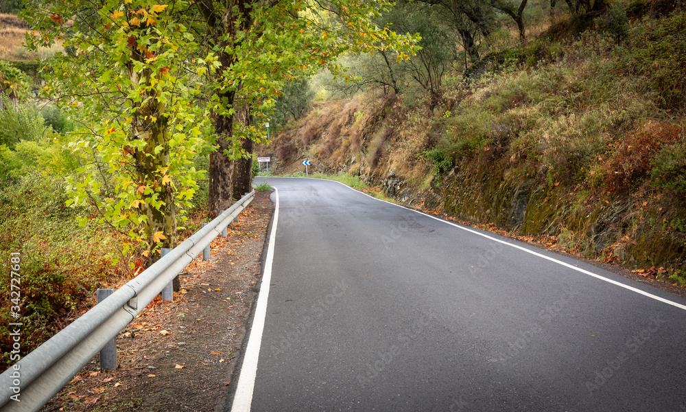 A paved road approaching Almonaster la Real town in Autumn, province of Huelva, Andalusia, Spain A paved road approaching Almonaster la Real town in Autumn, province of Huelva, Andalusia, Spain