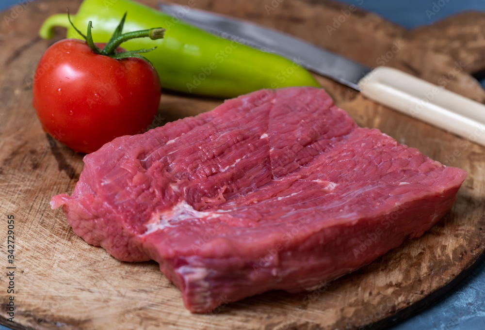 Tomatoes, peppers, beef fillets on a wooden board