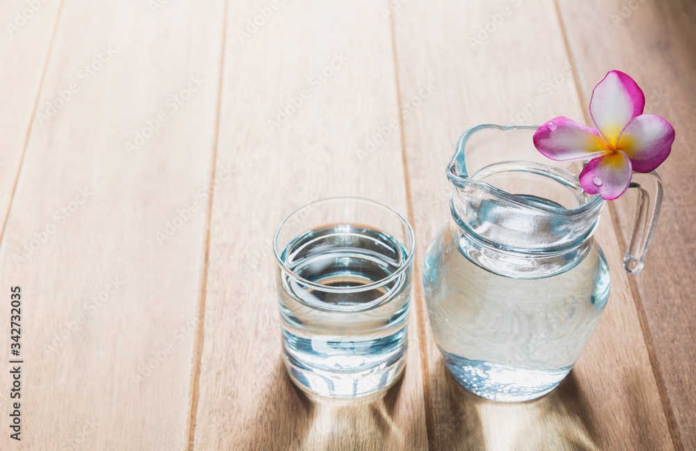 Water glass with glass jar on wooden table. Glass and clean drinking water with copy space. Water glass with glass jar on wooden table. Glass and clean drinking water with copy space.