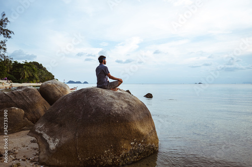 Young  man meditating on the beach