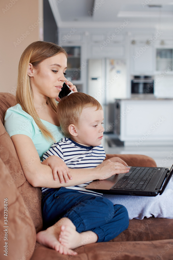 Busy mother holding her son and talking on the phone Busy mother holding her son and talking on the phone