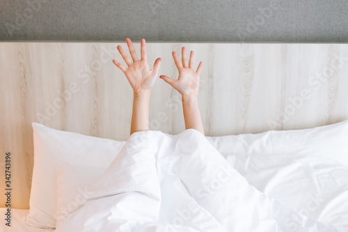 Capture of female arm stretching while waking up on bed.