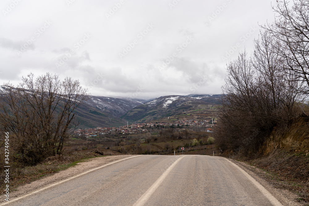 Empty road leading to turkish village in the valley, mountain landscape